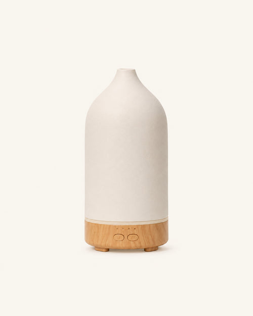 The Vagar ceramic diffuser, chalk-white cover on a wood-grain base, on a plain cream ground